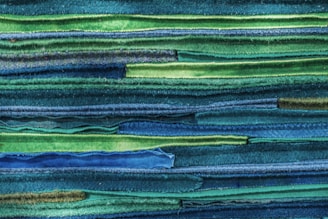 Stacks of folded fabrics showcasing diverse textures and colors in a cozy studio.