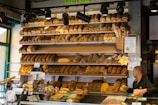 A friendly staff member arranging fresh bread in the bakery section.