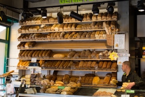 A friendly staff member arranging fresh bread in the bakery section.