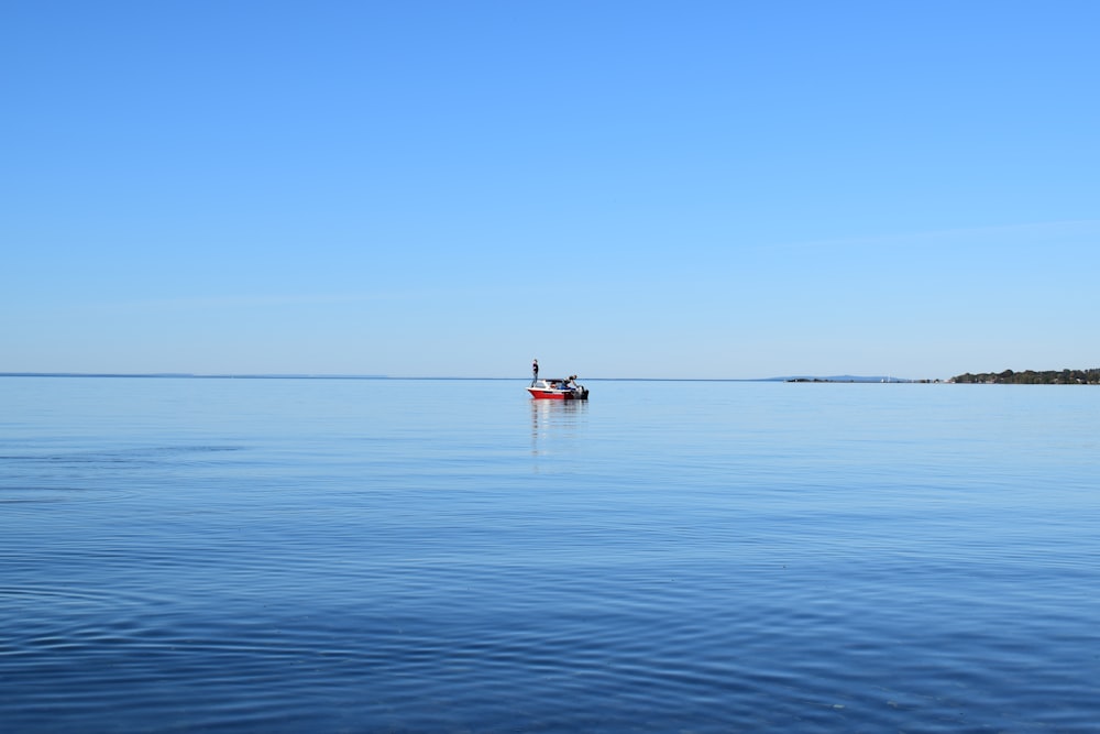 person in red boat on sea during daytime