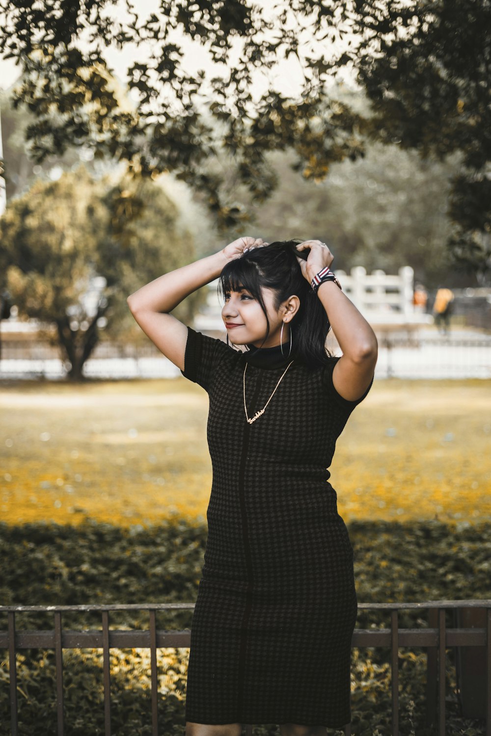 woman in black dress standing on green grass field during daytime