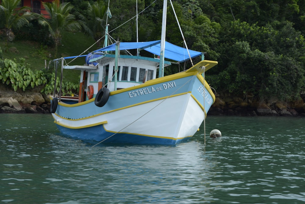 yellow and blue boat on water during daytime