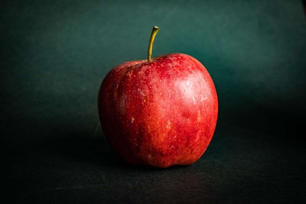 Frutto di mela rossa su tessuto nero