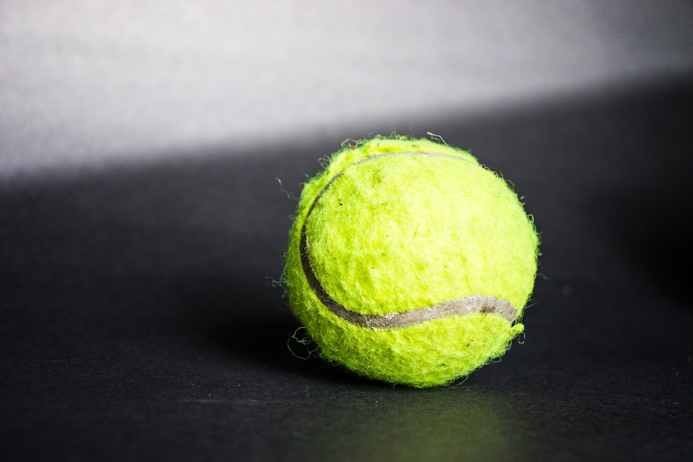 bola de tênis verde no têxtil preto