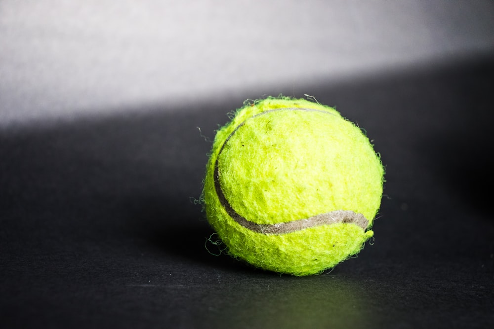 Pelota de tenis verde sobre textil negro