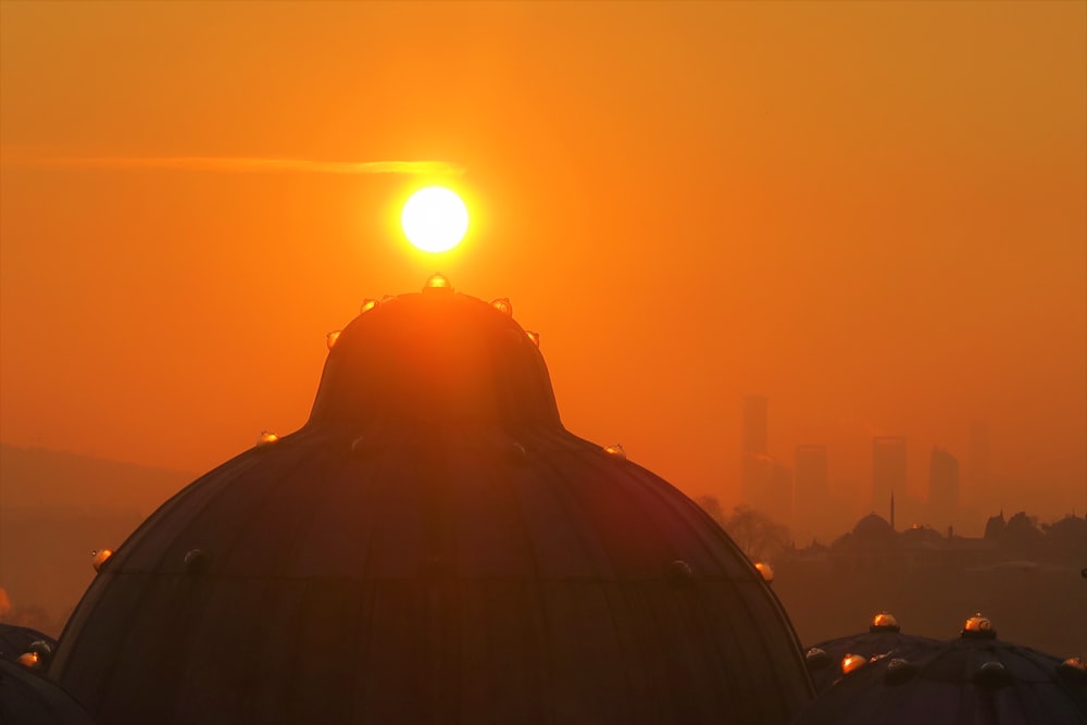 silhueta de pessoas no topo do edifício durante o pôr do sol