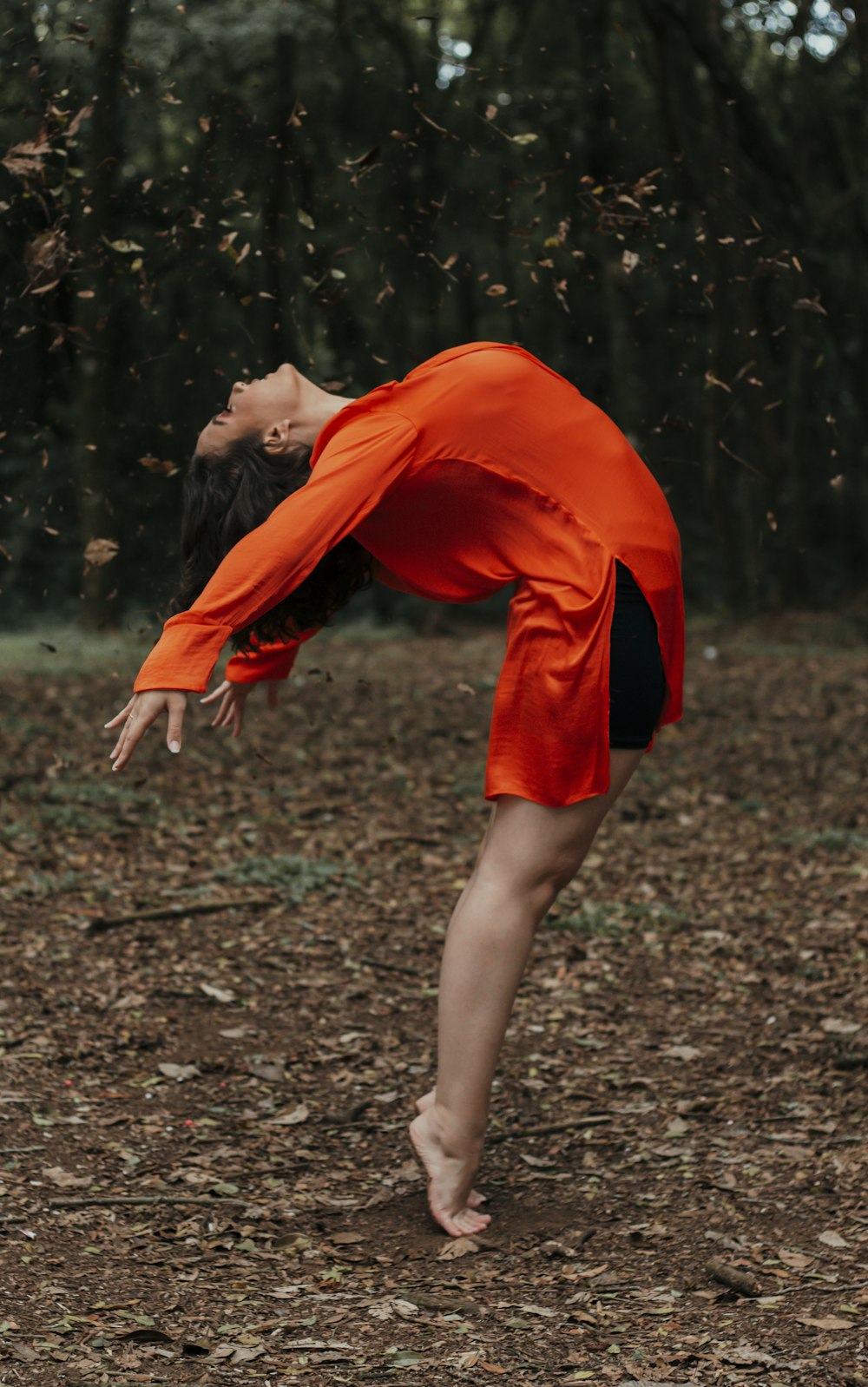 Frau in orangefarbenem Kleid auf dem Boden stehend