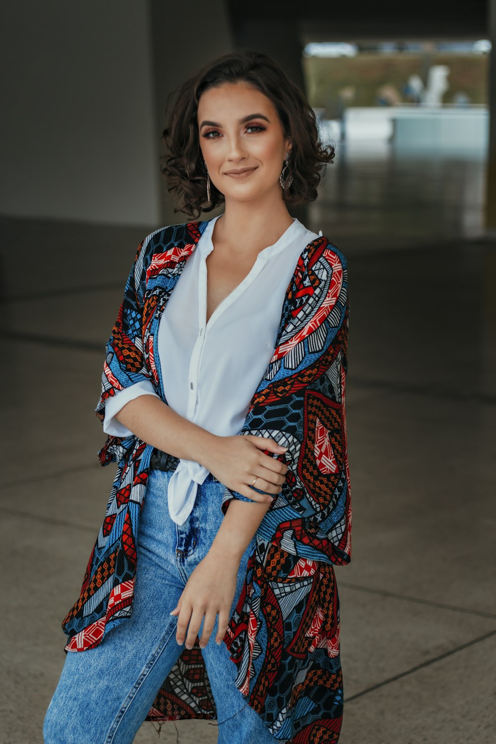 woman in white button up shirt and red blue and white tribal print cardigan