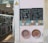 A shopfront displays two chalkboards advertising original tiles and handmade ceramics. The boards are adorned with colorful, intricate tile designs. Below them, two ornate ceramic plates with vibrant, circular patterns are mounted on a pale wall. Inside the shop, shelves are filled with a variety of ceramics and decorative plates.