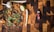 A wooden cutting board hosts a variety of spices and herbs including garlic, lime, cinnamon sticks, nutmeg, cloves, cardamom pods, mint leaves, and turmeric. To the right, there is a bottle labeled 'spice drops' with a dropper cap.