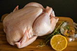 raw chicken meat on brown wooden chopping board