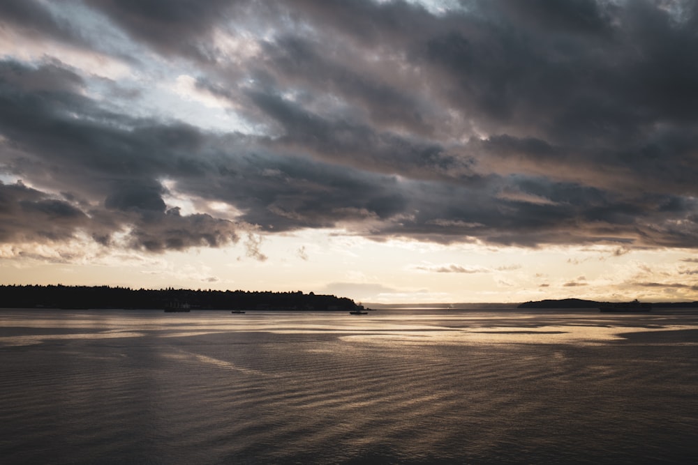 body of water under cloudy sky during sunset