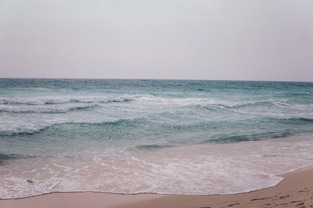 ocean waves crashing on shore during daytime