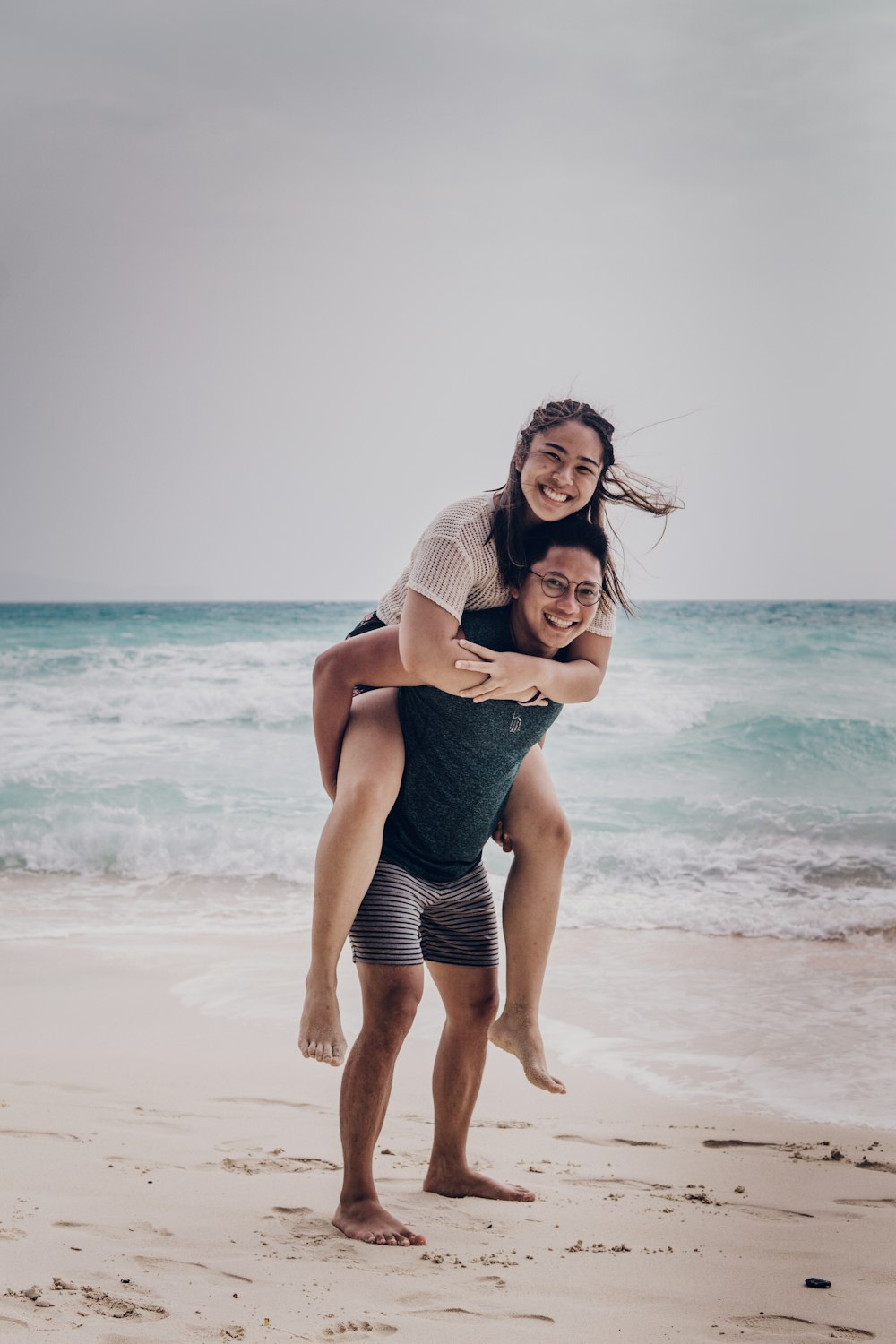 woman in blue denim shorts standing on beach during daytime