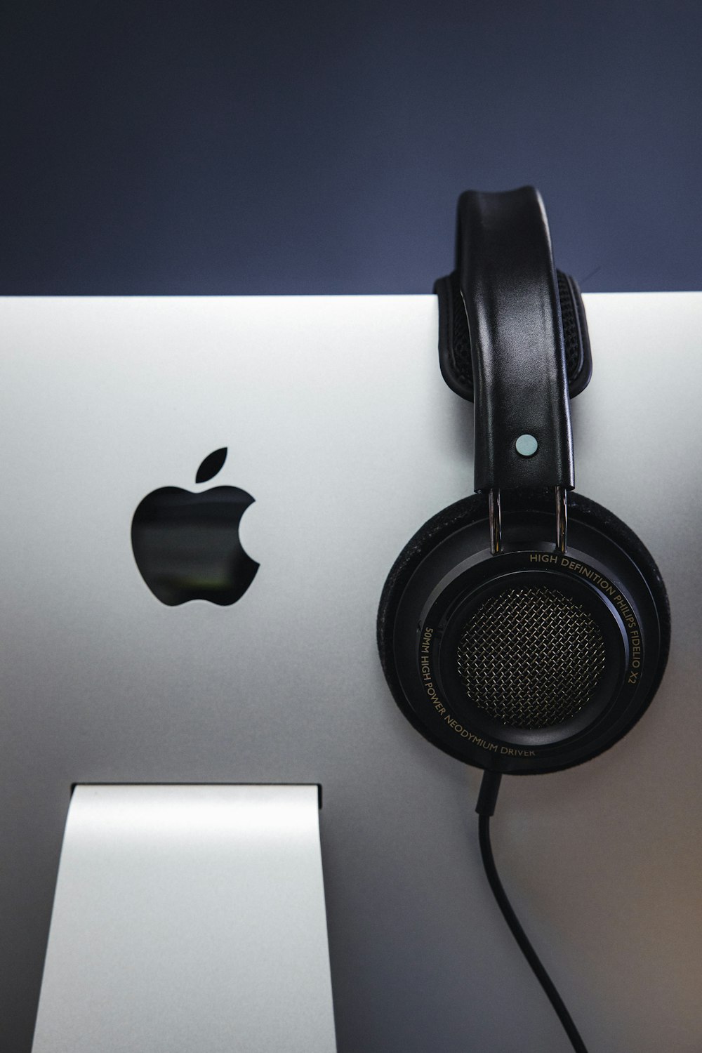 black and gray headphones beside silver imac