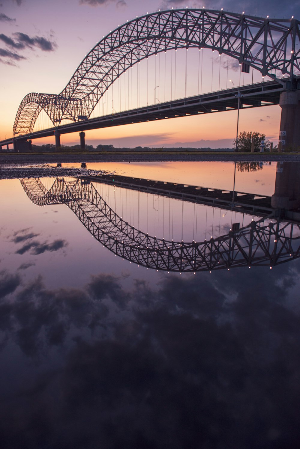 ponte de aço cinzento sobre o corpo de água durante a noite