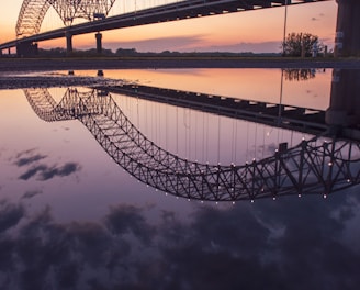 gray steel bridge over body of water during night time