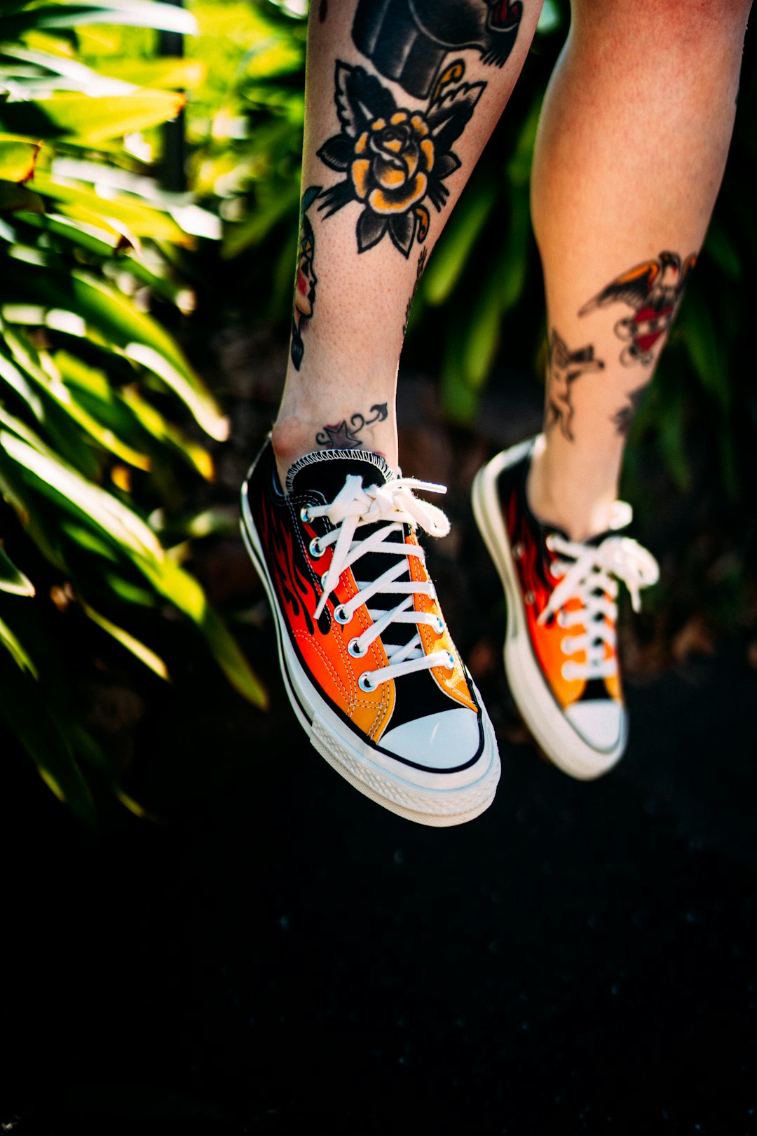 person wearing orange and white converse all star high top sneakers