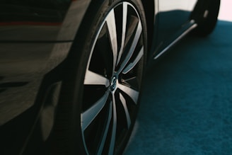 A close-up of shiny car wheels and tires displayed in a modern automotive shop.
