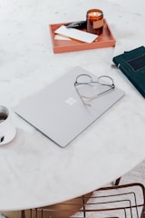 Clean workspace with a laptop, notebook, and coffee cup, minimalistic style.