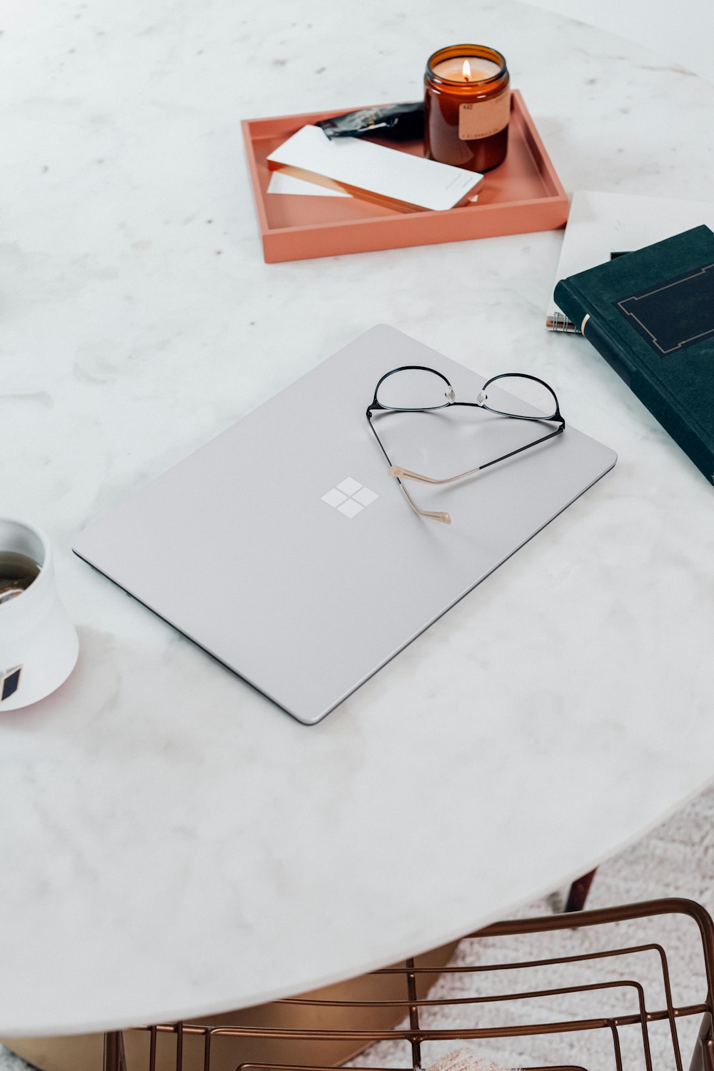 silver Microsoft Surface Laptop 3 in Platinum  beside black framed eyeglasses on white table