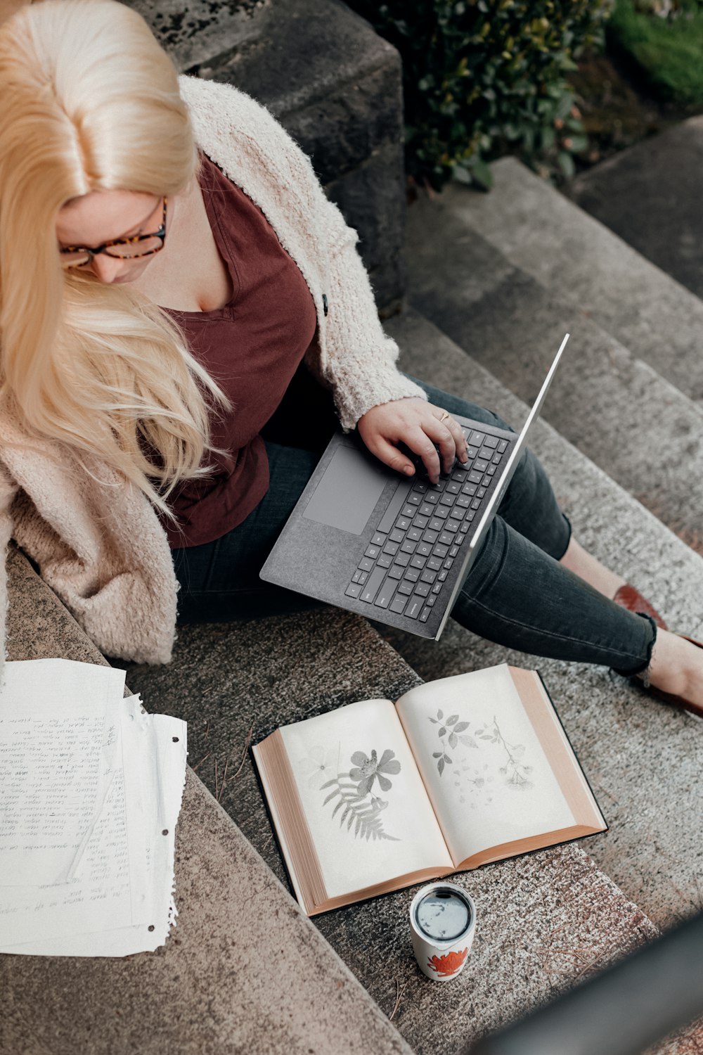 woman in white knit sweater using Microsoft Surface Laptop 