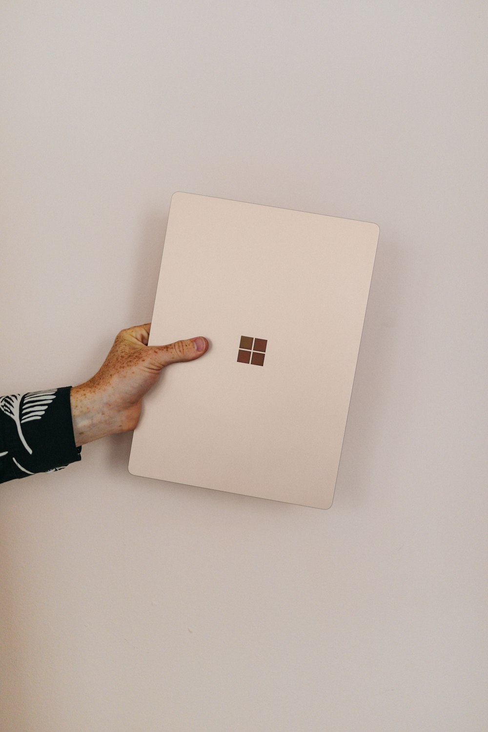 persona sosteniendo piedra arenisca microsoft Surface laptop portátil