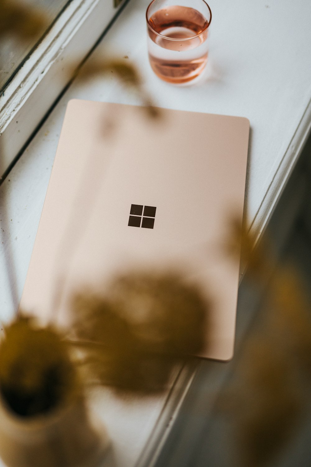 Sandstone coloured Surface Laptop on a window ledge