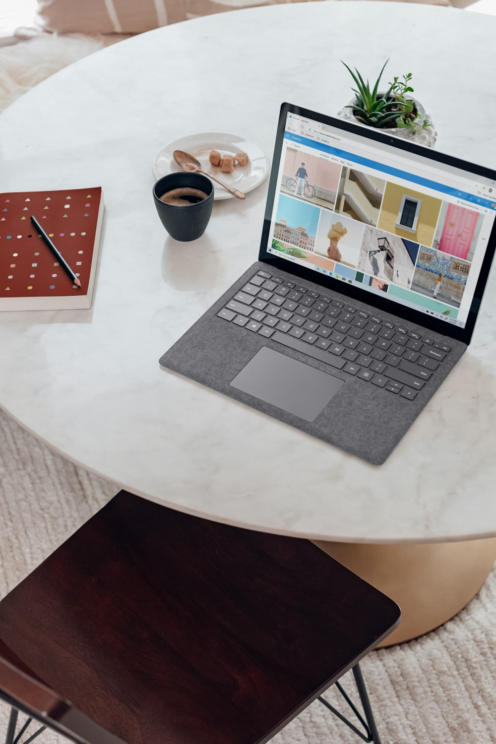 silver coloured Microsoft surface laptop on white round table