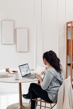 woman in gray sweater using microsoft surface laptop 