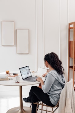 woman in gray sweater using microsoft surface laptop 