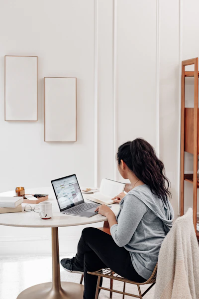 woman in gray sweater using microsoft surface laptop 