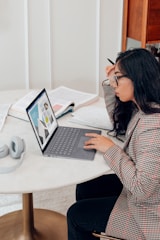 woman in red and white plaid dress shirt using microsoft surface laptop 