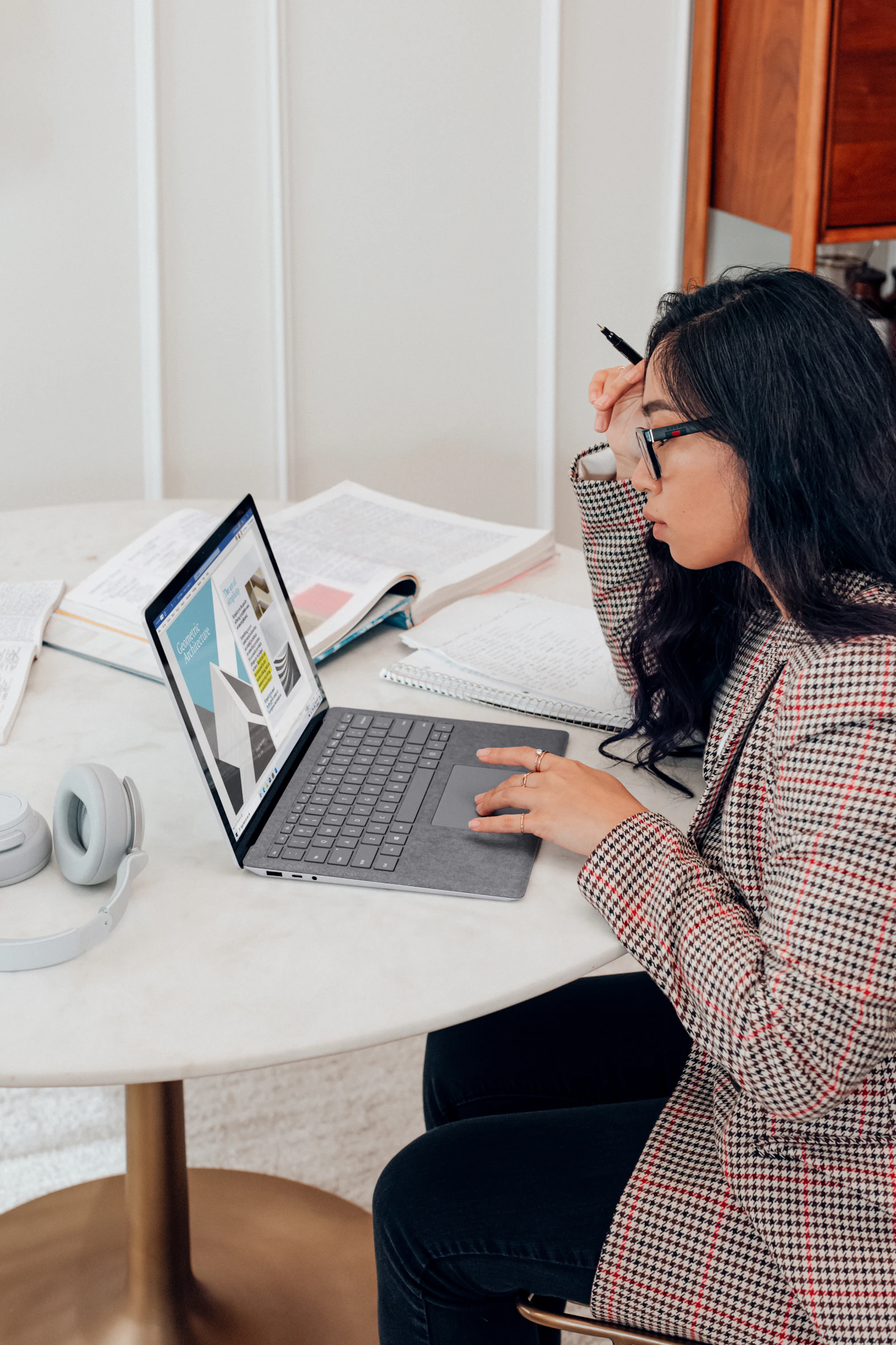 Woman studying English with a laptop and notes