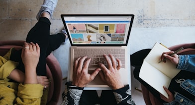 person using microsoft surface laptop on lap with two other people