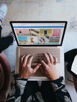 person using microsoft surface laptop on lap with two other people