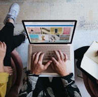 person using microsoft surface laptop on lap with two other people