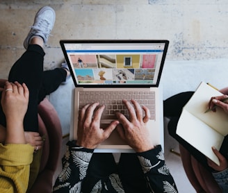 person using microsoft surface laptop on lap with two other people