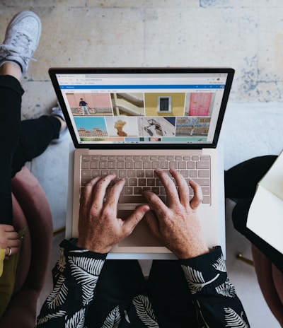 person using microsoft surface laptop on lap with two other people