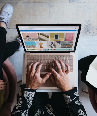 person using microsoft surface laptop on lap with two other people