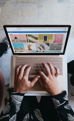 person using microsoft surface laptop on lap with two other people