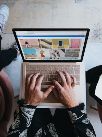 person using microsoft surface laptop on lap with two other people