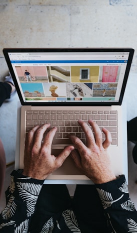 person using microsoft surface laptop on lap with two other people