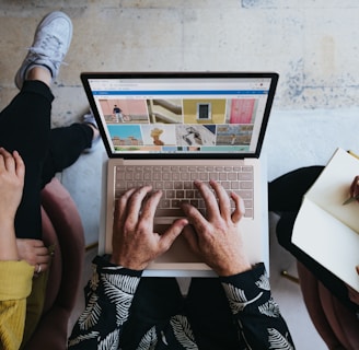 person using microsoft surface laptop on lap with two other people