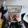 person using microsoft surface laptop on lap with two other people