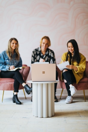 A friendly team collaborating over a laptop with pink cherry branding visible.