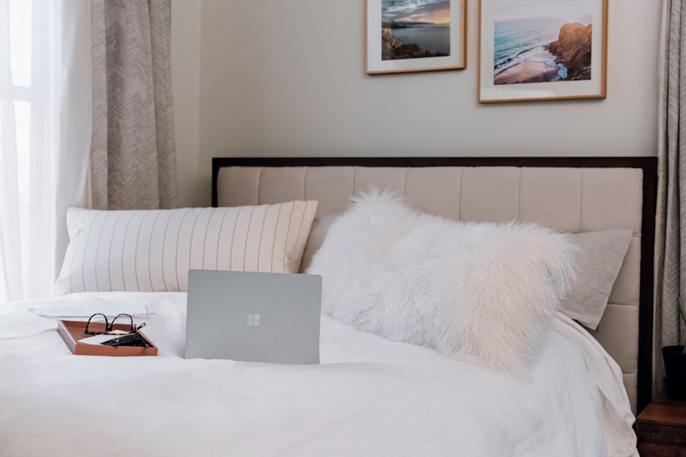 silver microsoft surface laptop on white bed