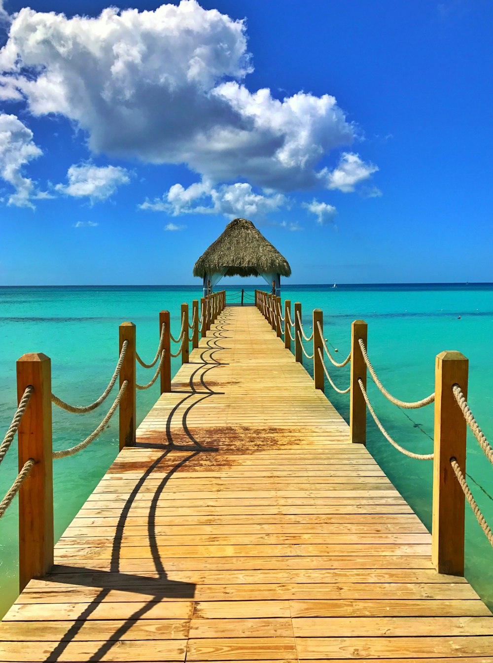 brown wooden dock on blue sea under blue sky during daytime