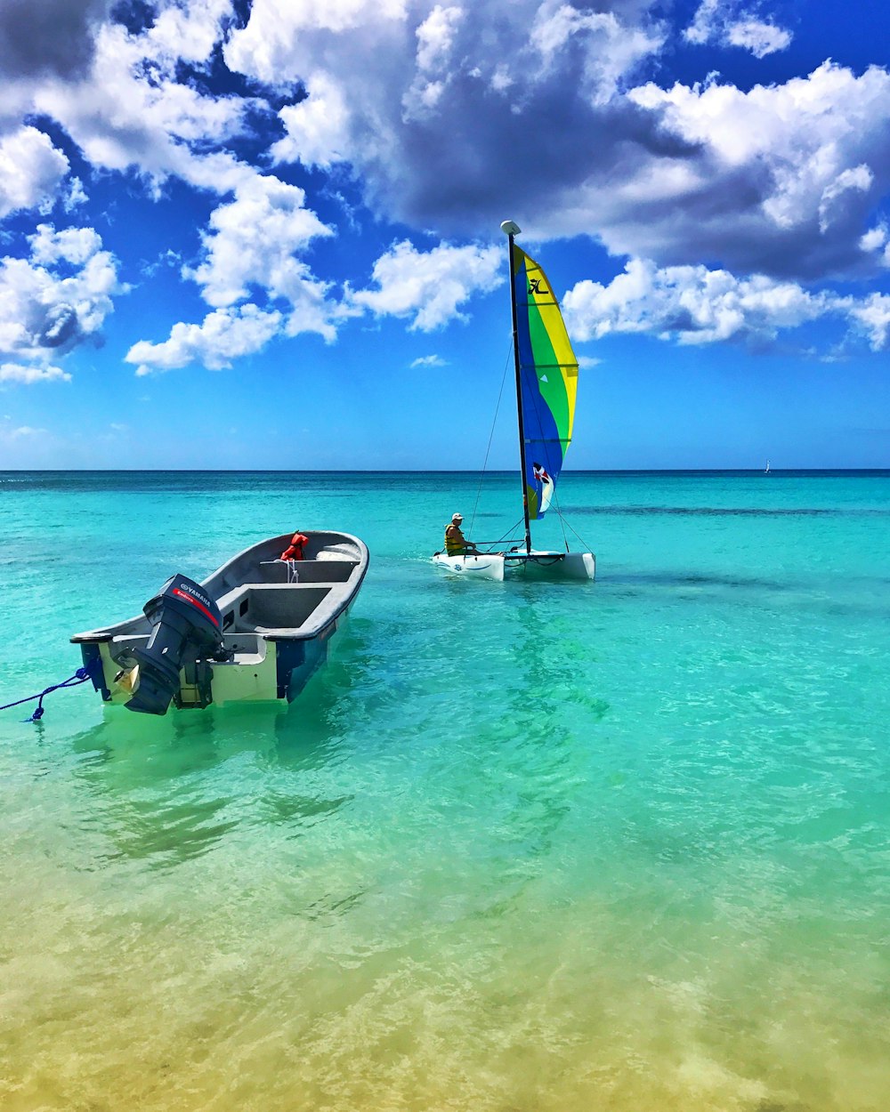 2 person riding on white and blue boat on sea during daytime