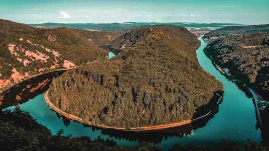 brown and green mountain beside blue body of water during daytime in Saarbrücken Germany